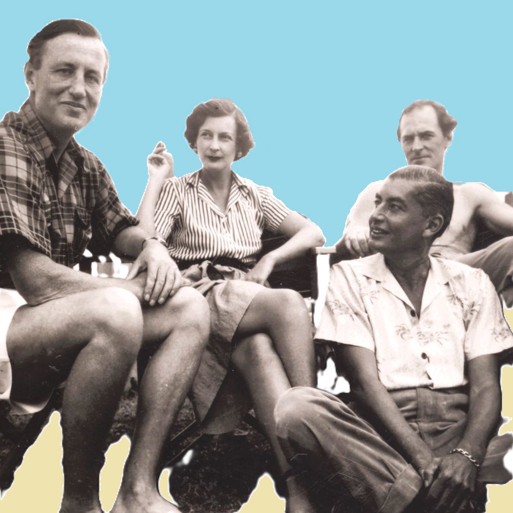 Ian Fleming seated with three other people in a casual setting. The group includes two women, one in a plaid shirt, one in a striped blouse, and a shirtless man. The background has been edited, so the people are set against solid blue.
