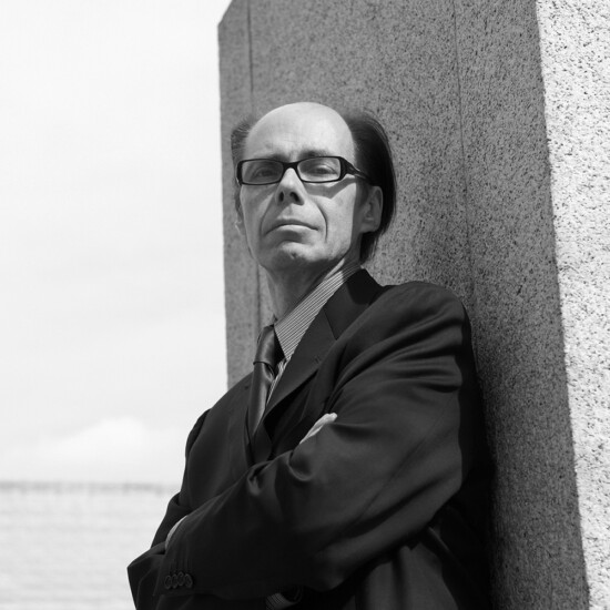 Black and white photograph of author Jeffery Deaver, a middle aged white man wearing glasses.