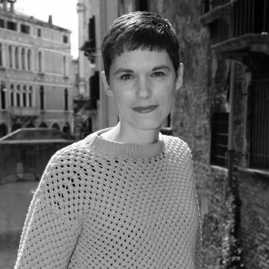 Black and white photograph of author Kim Sherwood, a white woman with short, dark hair.