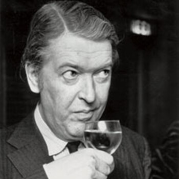 Black and white photograph of author Kingsley Amis, a white man drinking from a wine glass.