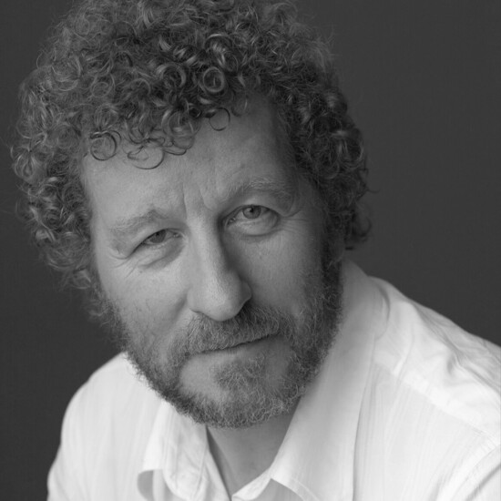 Black and white photograph of author Sebastian Faulks, a middle aged white man with a beard and curly hair.