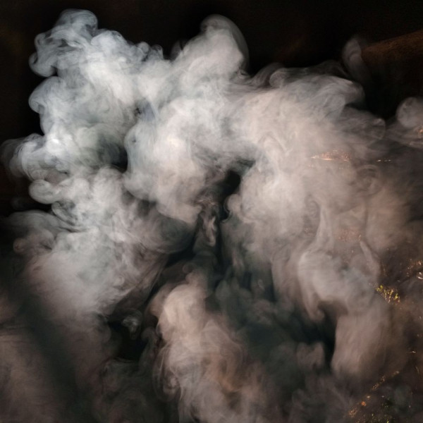 Cloud of smoke against a black background.