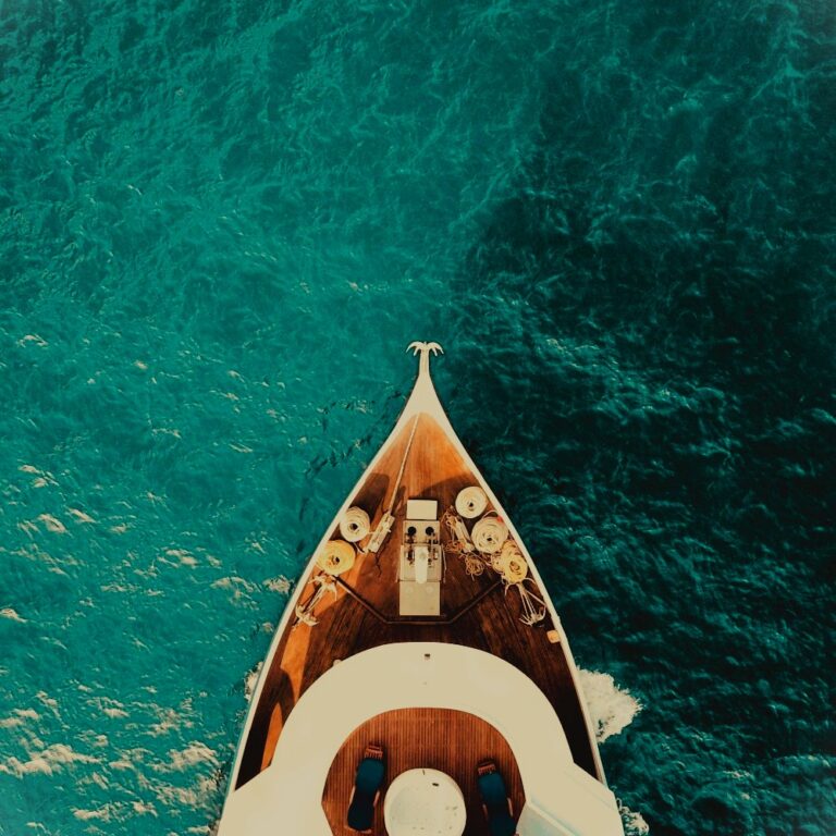 birds-eye view of the prow of a yacht against a bright blue sea