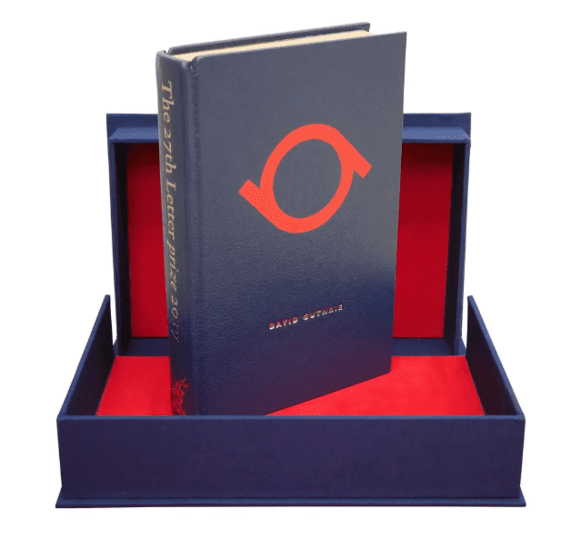 Photo of the prize for the 27th letter competition, a leather bound book with the winning letter on the cover.